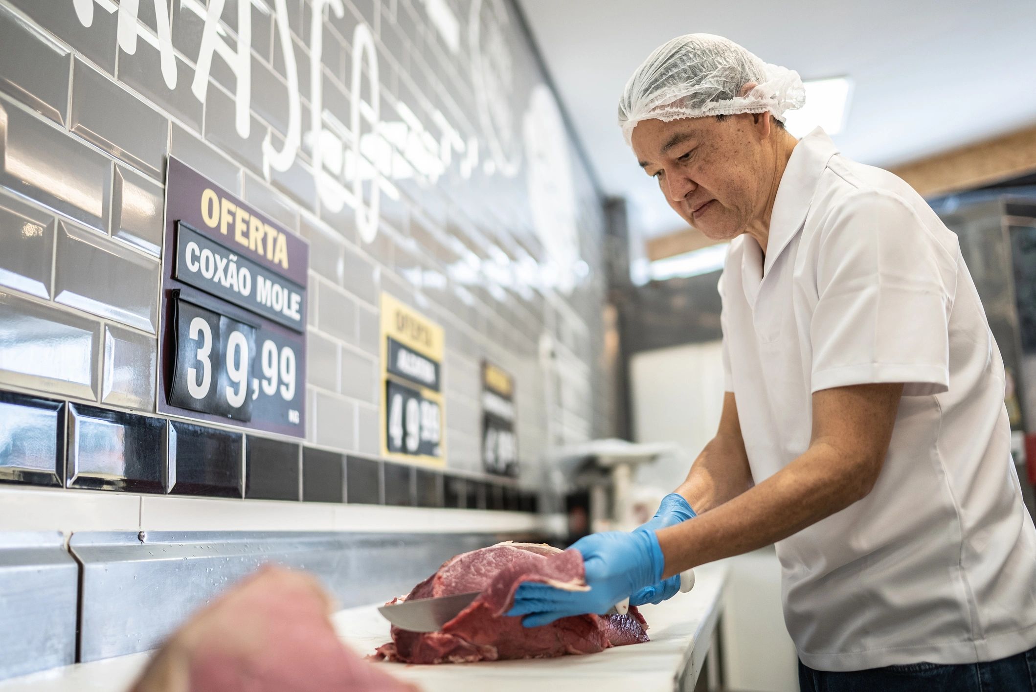 Butcher slicing meat at a butcher shop counter