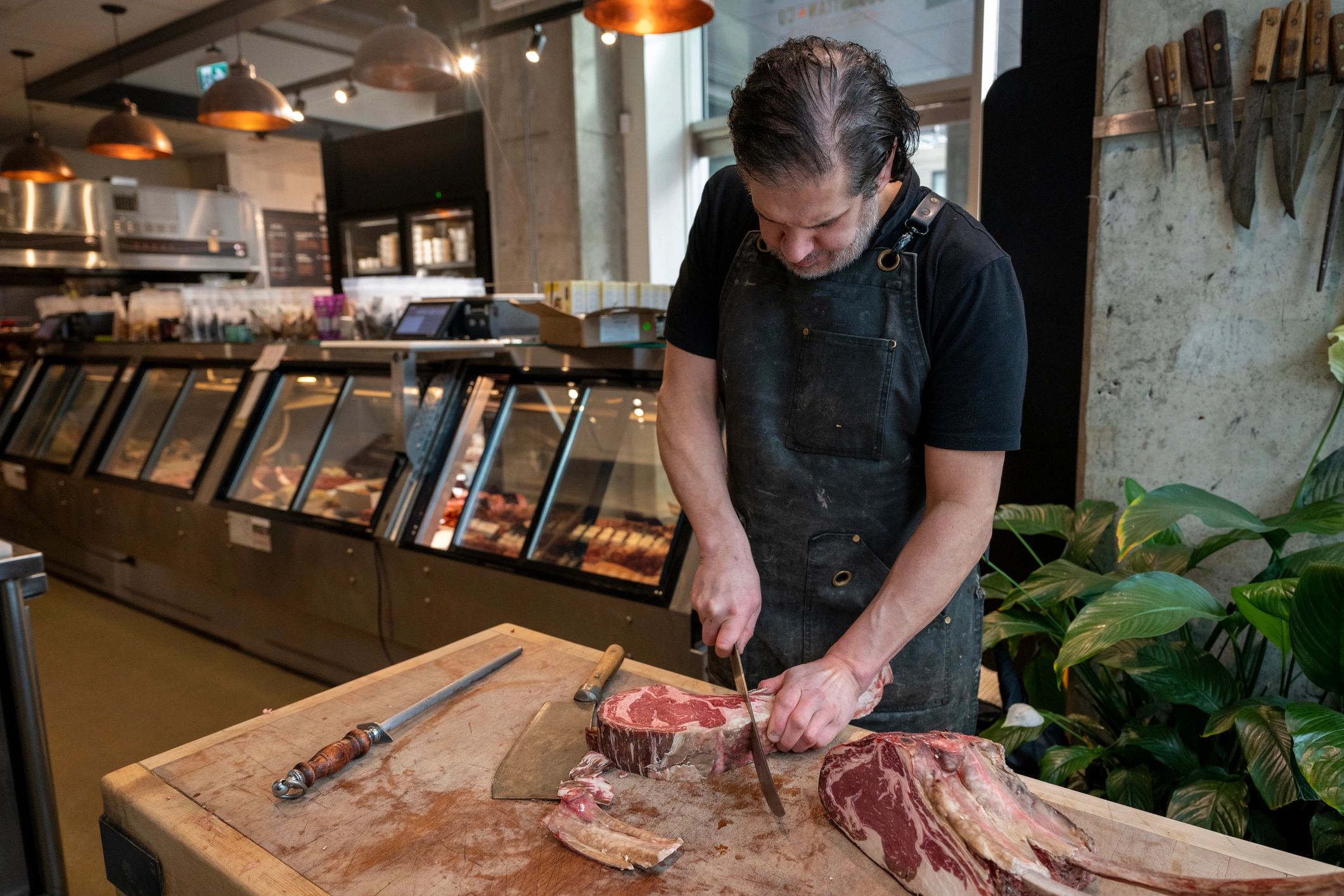 Butcher slicing a beef roast on a cutting board